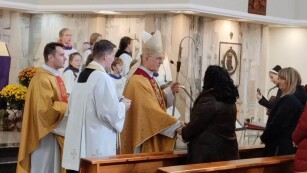 dyrektor szkoły odbiera gratulacje od biskupa i księży podczas mszy w kościele