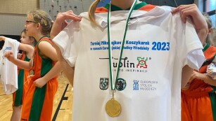uczennica prezentuje pamiątkową koszulkę i medal z turnieju