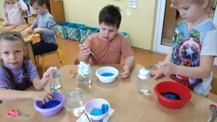 grupa dzieci przeprowadza eksperymenty z wodą