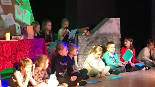 grupa dzieci na scenie w sali teatralnej