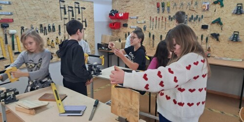 grupa uczniów podczas pracy w pracowni stolarskiej