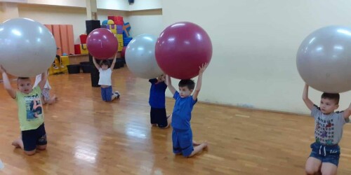 uczniowie podczas zajęć gimnastycznych z dużymi piłkami
