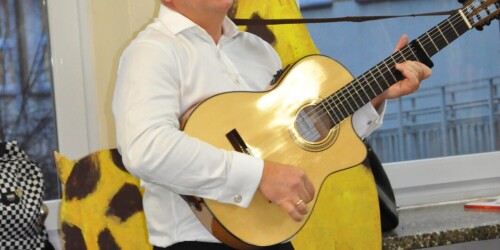 nauczyciel akompaniuje na gitarze podczas występu