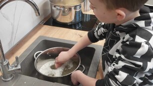 uczeń zmywa garnek w zlewozmywaku