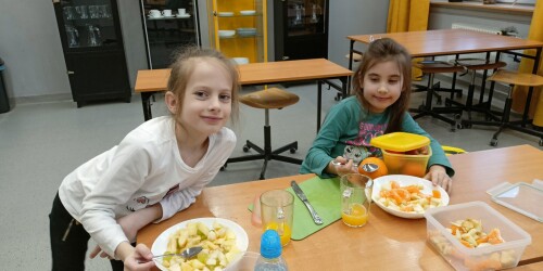 dziewczynki jedzą gotową sałatkę owocową