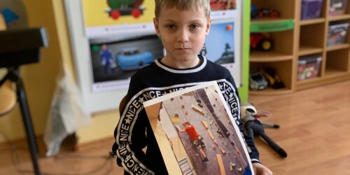 chłopiec prezentuje swoje zdjęcie ze ścianki wspinaczkowej