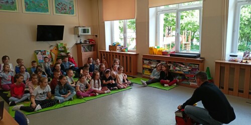 grupa dzieci słucha i ogląda jak udzielać pomocy