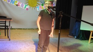 chłopiec stoi przed mikrofonem i recytuje wiersz