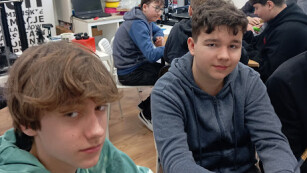 chłopcy siedzący przy stoliku podczas warsztatów